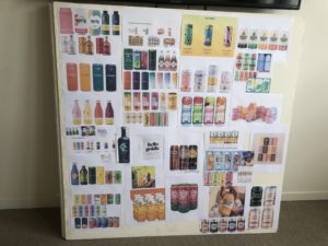 A 4'x4' foam core board with twenty different color printouts of beverage packaging